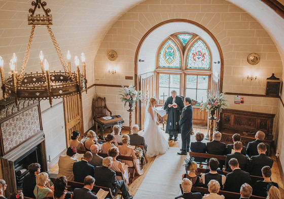 View from above of ceremony with stained glass windows and candle chandelier